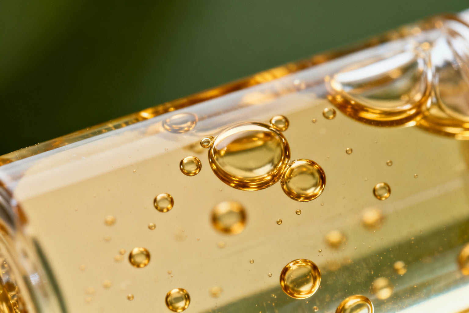 Gouttes d'huile doree sur fond neutre, actif ceramides